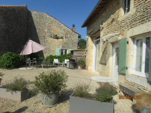 a patio with a table and an umbrella next to a building at L'ammonite in Chaunay