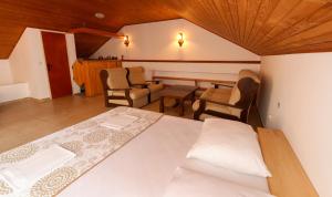 a bedroom with a bed and a table and chairs at Kuća na plaži in Razvala