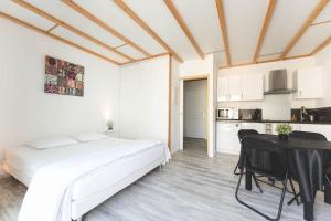 a bedroom with a bed and a table and a kitchen at Le gite du buis in Montamisé