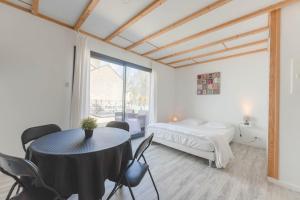 a bedroom with a bed and a table and chairs at Le gite du buis in Montamisé