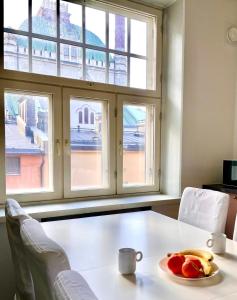a table with a plate of fruit in front of a window at Elegant Jugend city retreat 79m2 in Helsinki +1 photo