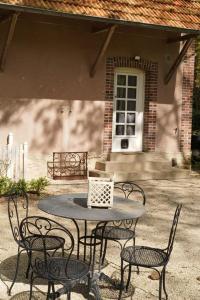 a table with four chairs and a laptop on it at Maison de Sylvain in Barjouville