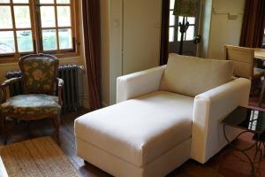 Una sala de estar con un sofá blanco y una silla. en Maison de Sylvain, en Barjouville