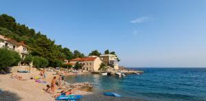 a group of people on a beach near the water at Kuća na plaži in Razvala