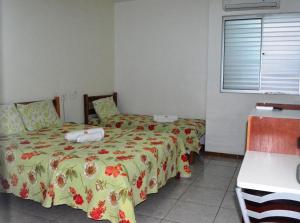 a hotel room with two beds and a window at Brisa Do Vale Pousada in Itaobim
