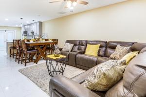 ein Wohnzimmer mit einer Ledercouch und einem Tisch in der Unterkunft Golf, Shop and Unwind Home 9 Mi to Ocean Inlet Park in Atlantis + 16 Fotos