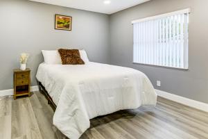 ein Schlafzimmer mit einem weißen Bett und einem Fenster in der Unterkunft Golf, Shop and Unwind Home 9 Mi to Ocean Inlet Park in Atlantis