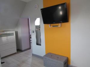 a living room with a tv on a wall at Le gîte de la butte in Champagné-Saint-Hilaire