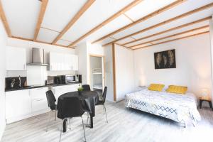 a bedroom with a bed and a table and chairs at Le gite du marronnier in Montamisé