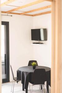 a black table with chairs and a tv on a wall at Le gite de l'erable in Montamisé
