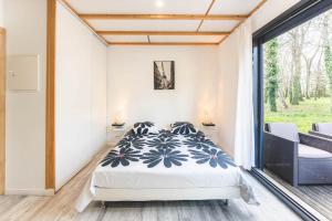 a bedroom with a bed and a large window at Le gite de l'erable in Montamisé