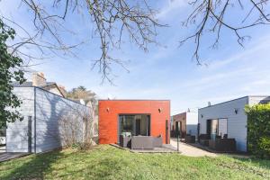 a house with an orange wall in a yard at Le gite du prunus in Montamisé