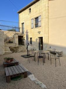 a patio with a table and chairs and an umbrella at Le troglo du château in Beaumont