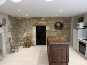a kitchen with a stone wall and a black door at Le troglo du château in Beaumont