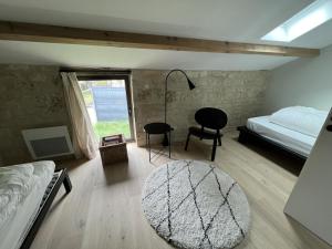 a bedroom with a bed and a chair and a rug at Le troglo du château in Beaumont