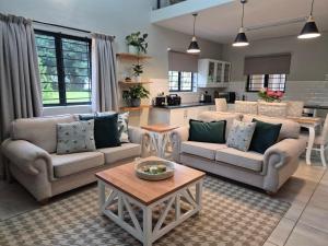 ein Wohnzimmer mit zwei Sofas und einem Tisch in der Unterkunft Courtleigh Cottage in Hilton