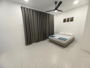 a bedroom with a bed and a ceiling fan at SWee Garden Homestay in Kota Tinggi