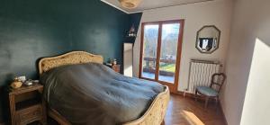 a bedroom with a bed and a chair and a window at La cherpée in Lhommaizé