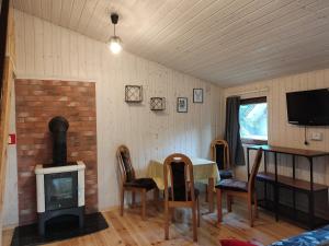 ein Wohnzimmer mit einem Tisch und einem Holzofen in der Unterkunft OWS Dorota in Kolbudy