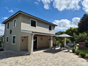 ein Haus mit einer Terrasse und einem Sonnenschirm in der Unterkunft Courtleigh Cottage in Hilton