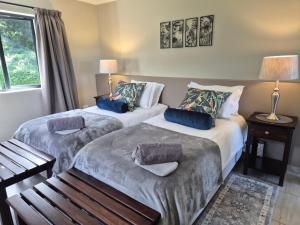 zwei Betten in einem Hotelzimmer mit Fenster in der Unterkunft Courtleigh Cottage in Hilton