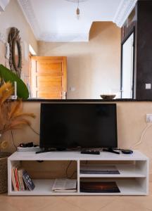a white entertainment center with a large monitor on it at Surf & bask HOME in Tamraght Ouzdar