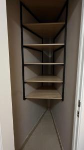 Habitación con armario pequeño con estanterías de madera. en Уютный апартамент, en Öskemen 2 fotos más