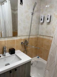 Un baño con ducha, lavabo y bañera. en Уютный апартамент, en Öskemen
