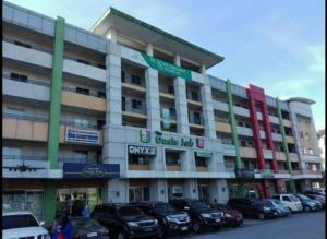 a large building with cars parked in front of it at Condo in Pasig - One Oasis Staycation in Manila
