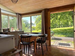 una cocina con mesa y sillas y una cocina con ventanas en The Duplex - Domaine De L'ô, en Bellacaud