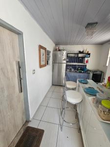 a kitchen with a refrigerator and a counter with stools at Junior aclimação in Sao Paulo