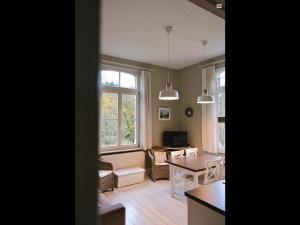 a living room with a table and a dining room at La Villa des Roses in Durbuy