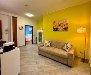 a living room with a couch and a yellow wall at El Prestinée Box auto gratuito in Milan