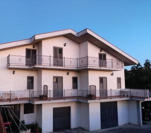 a large white building with balconies and gates at Nonno Pierino affittacamere in Civitella Casanova