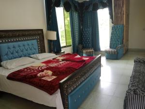 a bedroom with a large bed with a red blanket at BHURBAN view APARTMENTS in Murree