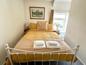 ein Schlafzimmer mit einem Bett mit zwei Handtüchern darauf in der Unterkunft Miners cottage(1840)Nr. Brecon,Tower Zip & Bike Pk in Aberdare