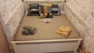 un lit dans une chambre avec serviettes et oreillers dans l'établissement Villa con trullo Santo Scalone, à Carovigno
