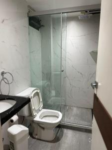 Un baño con inodoro y ducha de cristal. en Moscatel Apartament, a pocas cuadras de la Plaza Principal, en Tarija