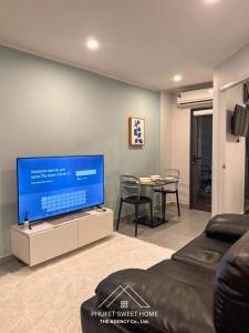a living room with a flat screen tv and a table at Condo for rent by phuket sweet home chalong in Ban Klang