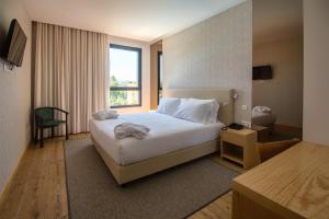 a hotel room with a bed and a window at Flag Hotel Celorico Palace in Celorico de Basto