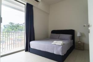 Un dormitorio con una cama y una ventana grande. en Cozy Seaview Escape 2BR 6pax bythesea bathroom, en Pulau Pinang