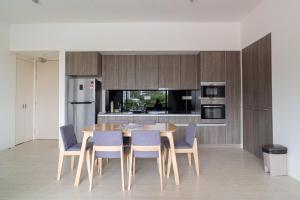 cocina con mesa de madera y sillas azules en Cozy Seaview Escape 2BR 6pax bythesea bathroom, en Pulau Pinang 20 fotos más