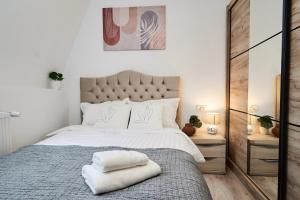 a bedroom with a large bed with two towels on it at KIM & C O Loft - Evadare Romantică - By Open House in Timişoara