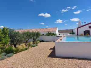 a garden with a swimming pool and a house at Quinta do Alvisquer in Alvisquer