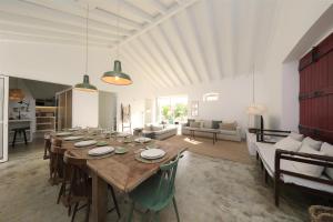 a dining room and living room with a large wooden table at Quinta do Alvisquer in Alvisquer