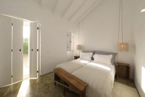 a white bedroom with a large bed and a window at Quinta do Alvisquer in Alvisquer