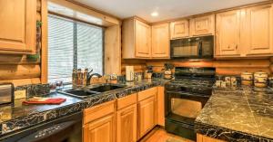 a kitchen with wooden cabinets and a sink and a stove at Cozy three bedroom cabin in Duck Creek in Duck Creek Village