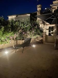 une chaise assise devant un bâtiment la nuit dans l'établissement Paradis de Provence Gite Jaune, à Le Pin 6 autres photos