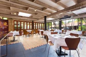 a restaurant with white tables and chairs and windows at Brisbane International Virginia in Brisbane