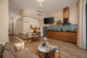 a living room with a couch and a table and a kitchen at Bullani-Sabi Hotel & Apartment in Da Nang